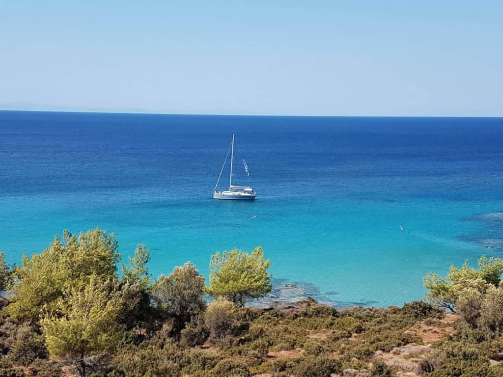 Aeolus yacht at Notos beach blue sky and emerald waters 